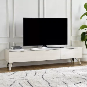 Sade tasarımı ve doğal ahşap dokusuyla öne çıkan Pureline Modern TV Ünitesi, salon ve oturma odalarına ferah ve şık bir görünüm kazandırır. Zamansız çizgileri sayesinde modern, minimalist ve nordik dekorasyon stilleriyle kolayca uyum sağlar. Geniş yüzeyi televizyon yerleşimi için ideal bir alan sunarken, kapaklı yapısı düzenli ve toplu bir görünüm oluşturur. Açık renk tonu mekânı daha aydınlık ve geniş gösterir, yaşam alanlarında dengeli bir atmosfer yaratır. Hem estetik hem de kullanışlı bir çözüm sunan modern TV sehpası, salonunda sade ama güçlü bir stil arayanlar için ideal bir tercihtir. Günlük kullanımda şıklığı ve düzeni bir arada sunar.