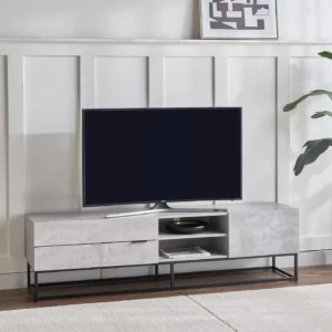 Betonix Loft TV Ünitesi, modern, endüstriyel ve minimal dekorasyon tarzını benimseyenler için özel olarak tasarlanmış güçlü bir TV ünitesi modelidir. Beton görünümlü yüzeyi ve siyah metal ayaklarıyla yaşam alanınıza modern bir karakter kazandırırken, fonksiyonel yapısıyla günlük kullanımda maksimum konfor sunar. Yüksek kaliteli MDF gövde, özel beton dokulu kaplaması sayesinde hem şık bir görünüm sağlar hem de çizilmeye ve aşınmaya karşı dayanıklıdır. Sağlam metal ayaklı TV ünitesi tasarımı, ürüne yüksek taşıma kapasitesi ve uzun ömürlü kullanım avantajı sunar. Yerden yüksek yapısı sayesinde temizlik kolaydır ve mekâna ferahlık katar. Kapaklı dolap bölmeleri ve açık raf alanları ile uydu alıcısı, oyun konsolu, modem, kitap, dergi ve dekoratif objeler için düzenli bir depolama alanı sunar. Bu özellikleri sayesinde salon TV ünitesi, oturma odası TV sehpası, endüstriyel TV dolabı ve modern TV konsolu olarak çok yönlü kullanım sağlar.